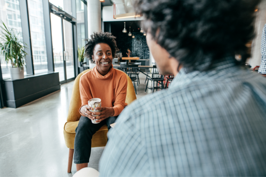 Two people talking and smiling in an office environment