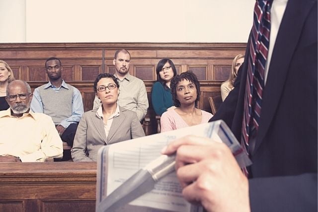 A jury listens to an attorney in a court room.