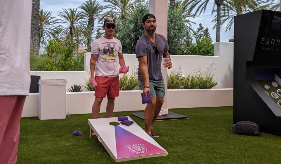 Two guys playing cornhole outside