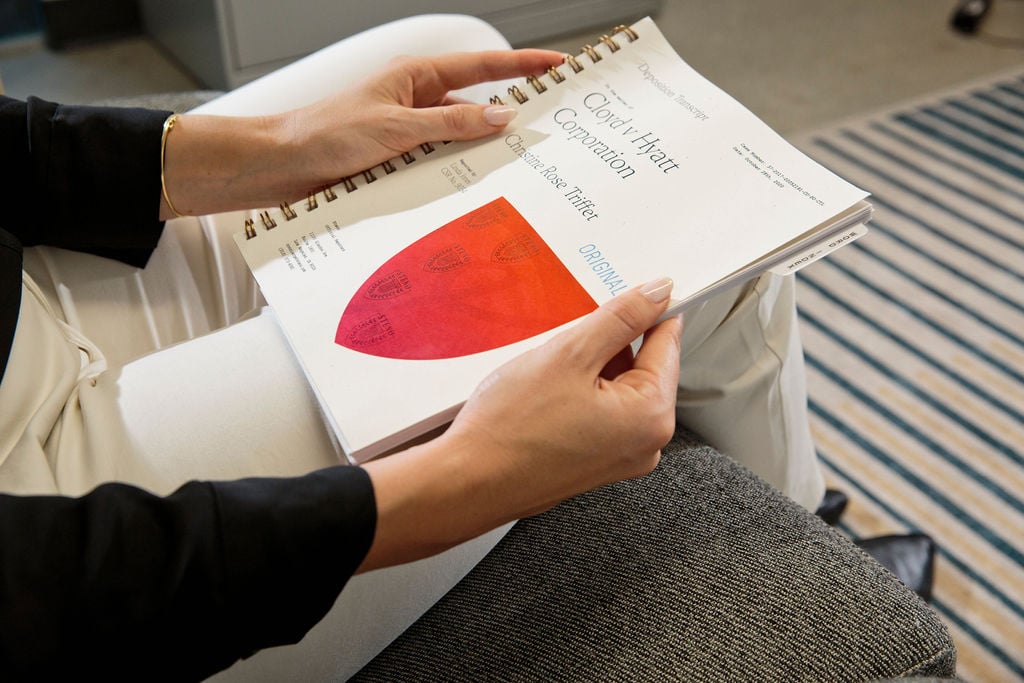 Woman sitting down holding a paper copy of a Steno transcript