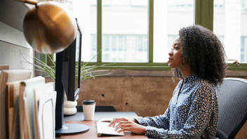 Woman working at a computer on Steno's Firm Dashboard.