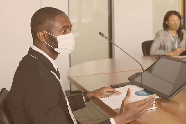 Man speaking into a microphone during a remote deposition.