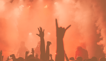 Photo of people at a concert with orange lighting