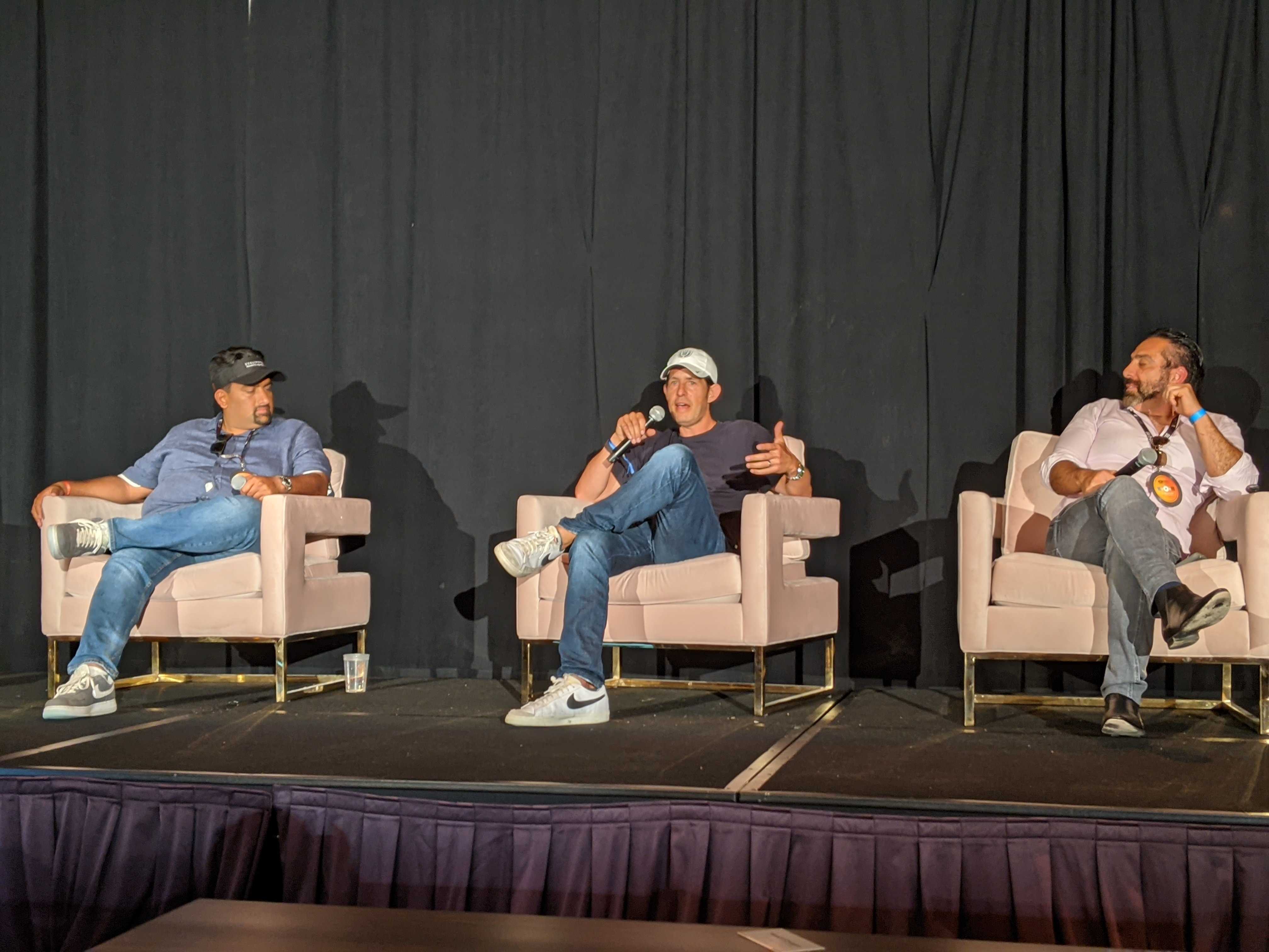 Dylan and other speakers sitting on stage.