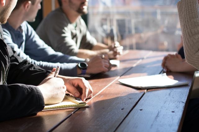 Group of people sitting around a table.